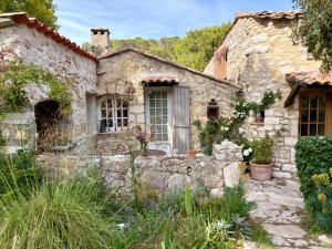 an old stone house with a garden in front of it at La Petite Bergerie in Éze +5 photos