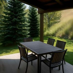 a table and chairs on a porch with a christmas tree at VAIL MOUNTAIN SUITE in Vail