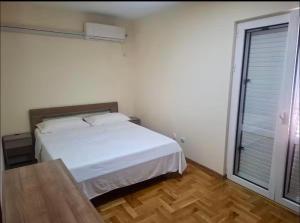 a bedroom with a white bed and a window at Cozy&Spacious in Kotor +2 photos