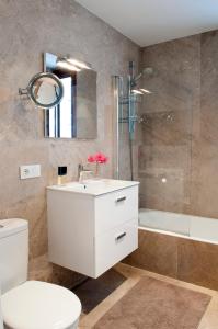 La salle de bains est pourvue d'un lavabo blanc et d'une douche. dans l'établissement Casa Damienne, à Porto Cristo