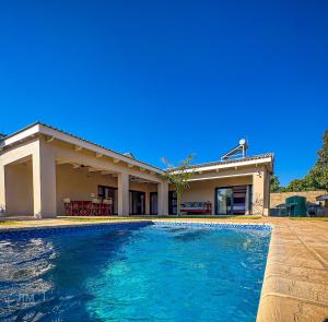 a swimming pool in front of a house at Judith & Sylvester Hideaway in Victoria Falls