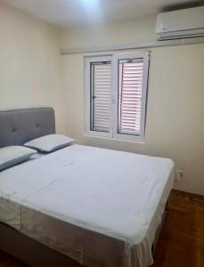 a bedroom with a large white bed and a window at Cozy&Spacious in Kotor