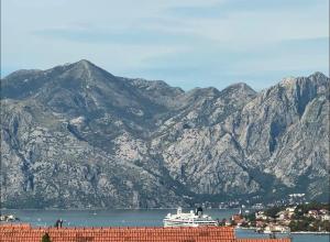 a cruise ship in the water next to mountains at Cozy&Spacious in Kotor