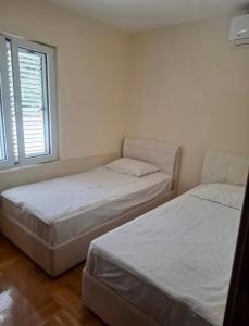 two twin beds in a room with a window at Cozy&Spacious in Kotor