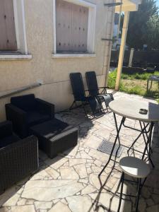 a patio with chairs and a table and a table and chairs at L abricosy in Drancy