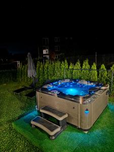 a hot tub in a yard at night at Къща Александра 2 in Dobrinishte