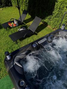 a hot tub in the grass in a yard at Къща Александра 2 in Dobrinishte +123 photos