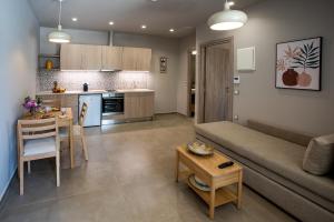 a living room and kitchen with a couch and a table at Ivy Residences with Pool in Ayía Varvára