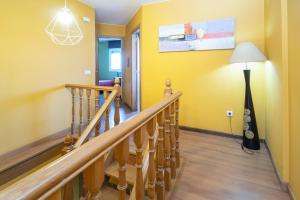 a hallway with yellow walls and stairs with a lamp at AG Piso Vazquez Parga Carballo in Carballo