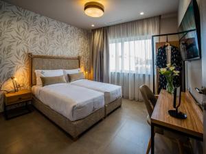a bedroom with a bed and a desk and a window at Ivy Residences with Pool in Ayía Varvára