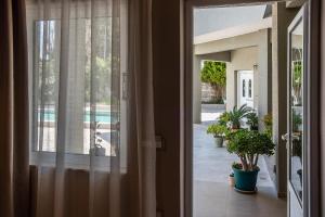 an open door of a house with a view of a pool at Ivy Residences with Pool in Ayía Varvára