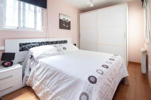 a bedroom with a white bed and a window at AG Piso Vazquez Parga Carballo in Carballo
