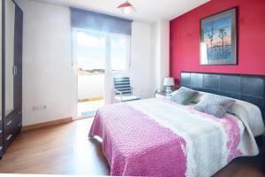 a bedroom with a large bed with a pink wall at AG Piso Vazquez Parga Carballo in Carballo