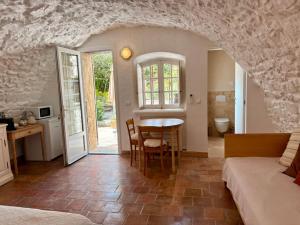 a room with a table and a kitchen with a bed at La Petite Bergerie in Éze