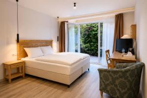 a bedroom with a bed and a desk and a window at Hotel Night4Flight Hamburg-Airport in Hamburg