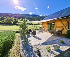 a house with a wooden deck with a table and chairs at Praterhof Chalet in Südtirol - Natur, Ruhe & Bergblick in Bressanone