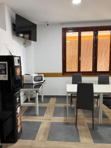 a room with a table and chairs and a kitchen at Pensión La Salve in Bilbao