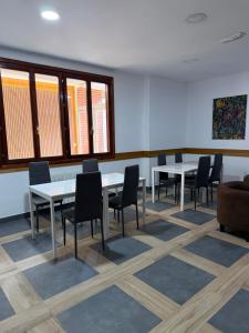 a dining room with tables and chairs and windows at Pensión La Salve in Bilbao