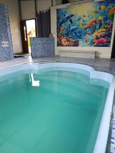 a swimming pool in a resort with a painting at Domki Helena Okuninka in Okuninka