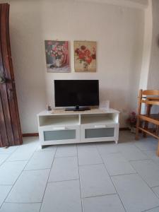 a living room with a television on a white cabinet at Pax Summer Apartment in Siviri