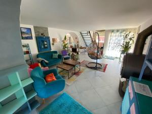 a living room with blue chairs and a table at La maison multicolore in Livron-sur-Drôme
