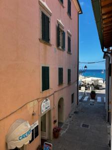 a building on a street next to the ocean at Bastianina's home in Marciana Marina