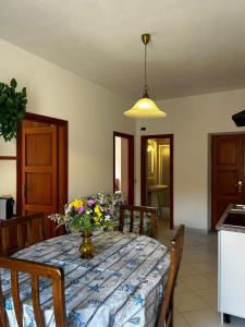 a dining room table with a vase of flowers on it at Bastianina's home in Marciana Marina +2 photos