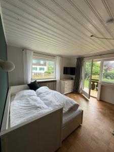 ein Schlafzimmer mit einem weißen Bett in einem Zimmer mit Fenstern in der Unterkunft Murmelruh in Mittenwald
