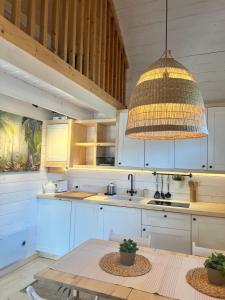 a kitchen with white cabinets and a pendant light at Domki nad morzem Sasino Mojo Miodno Checz in Sasino +217 photos