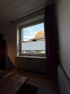 ein Fenster in einem Zimmer mit Blick auf einen Berg in der Unterkunft Murmelruh in Mittenwald