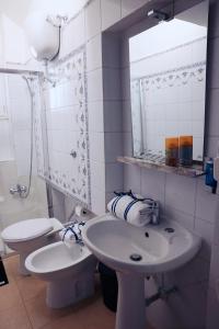 a bathroom with two toilets and a sink and a mirror at Western Termini Guest House in Rome +25 photos