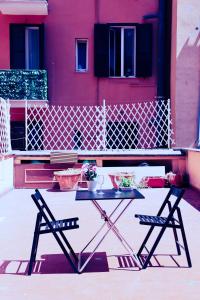 a table and two chairs in front of a pink house at Western Termini Guest House in Rome