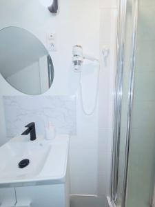 a white bathroom with a sink and a shower at Cosy logement Hyper Centre-ville in Quimper +30 photos