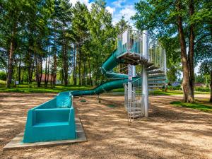 a green slide in a park with trees at Domki Heaven Kujanki in Kujanki