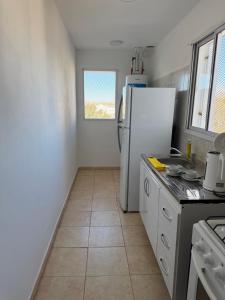 a kitchen with a refrigerator and a tile floor at Amelie 4 in General Roca