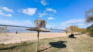 a sandy beach with two straw umbrellas on it at Los Abus in Colón