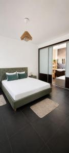 a bedroom with a large white bed and a mirror at AuraHouse Algarve in Lagoa