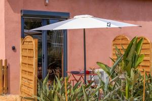 a table with an umbrella in front of a building at LA BRISA Duplex chaleureux in Hyères