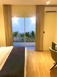 a bedroom with a bed and a large window with a view at Ahiva Village in Fulhadhoo