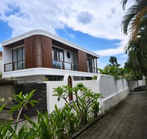 a house with a white and wooden facade at Hey-Sola Bali ,3BR Luxury Private Villa Near Canggu in Dalung