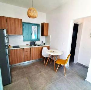 a kitchen with a table and a small table and chairs at Ελαιόλιθοι Μάνη Villas in Oitylo