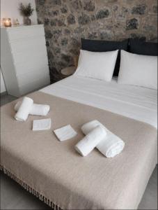 a bed with two towels and two blocks on it at Ελαιόλιθοι Μάνη Villas in Oitylo