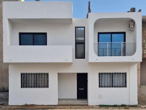 a white house with a round window and a balcony at Kaza Branka in Sal Rei