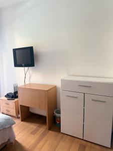 a bedroom with a desk and a tv on a wall at Splendid corner in Bečići