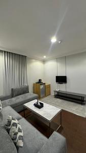 a living room with two couches and a flat screen tv at زون آفينيو للشقق المخدومة Zone avenue in Hafr Al-Batin