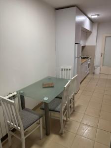 a kitchen with a green table and chairs in it at Apartman Ðurđevak in Stara Pazova +1 photo