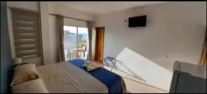 a bedroom with a bed and a window and a television at Hostal Cabañas Don Jorge in Puerto Baquerizo Moreno