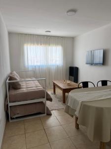 a bedroom with a bed and a table and a desk at Amelie 4 in General Roca