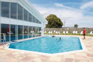 a group of people in a swimming pool next to a building at Kazamar in East Mersea