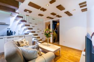 a living room with a couch and a spiral staircase at Ali Baba Apartment in Mostar